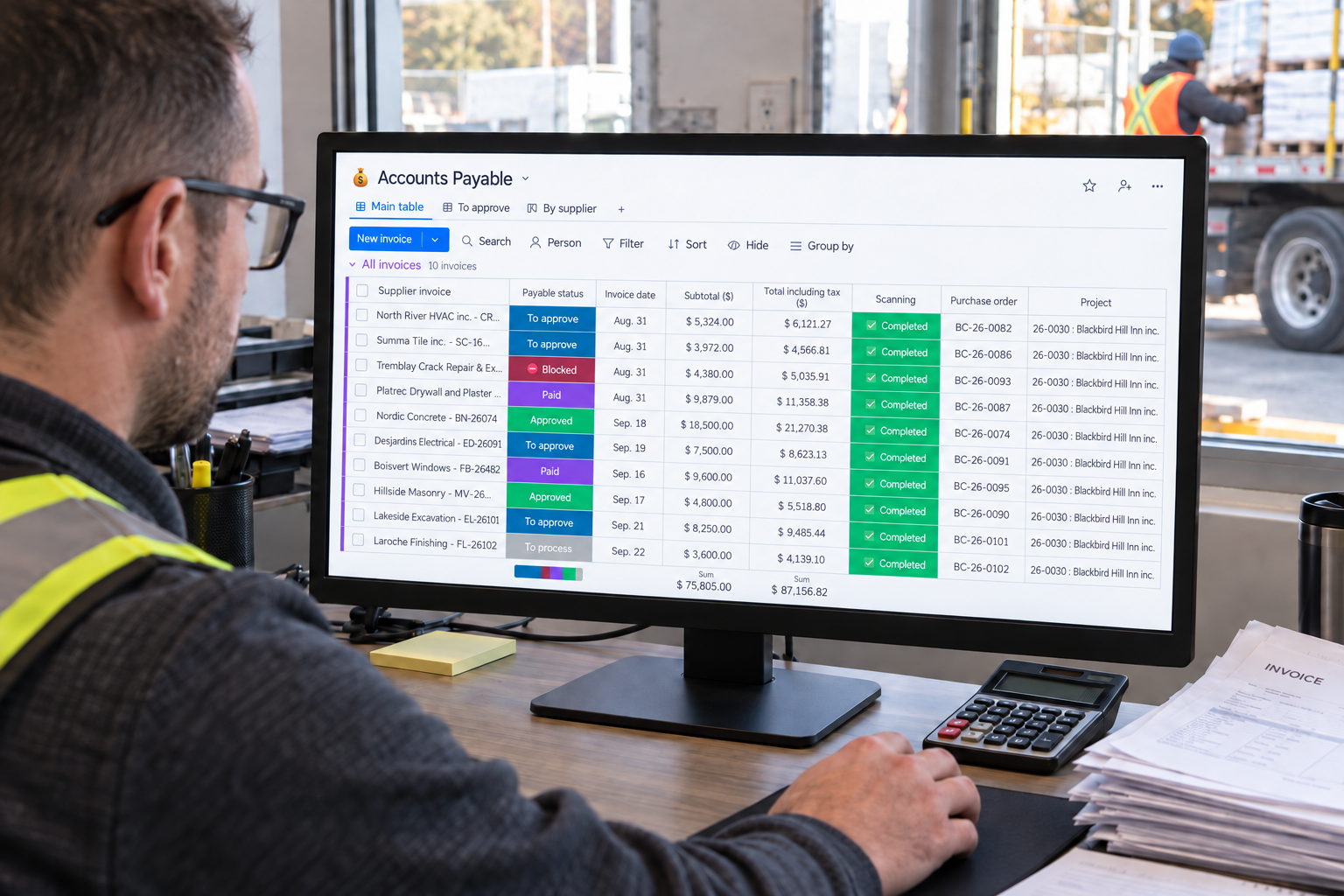 A manager checks ten supplier invoices, their statuses and purchase orders in Direction par Horizon near the materials receiving area.