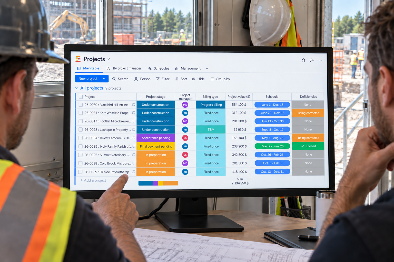 A project manager and superintendent review nine jobs, their schedules and deficiencies in Direction par Horizon from a site trailer.